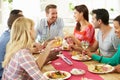 Group Of Friends Making Toast Around Table At Dinner Party