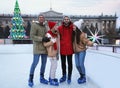 Group of friends near fence at outdoor ice rink Royalty Free Stock Photo