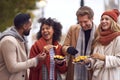 Group Of Friends Outdoors Wearing Coats And Scarves Eating Takeaway Fries In Autumn London Royalty Free Stock Photo