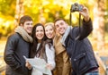 Group of friends with photo camera in autumn park Royalty Free Stock Photo