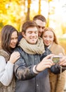 Group of friends with photo camera in autumn park Royalty Free Stock Photo