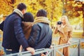 Group of friends with photo camera in autumn park Royalty Free Stock Photo
