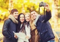 Group of friends with photo camera in autumn park Royalty Free Stock Photo