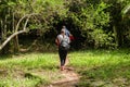 Group of friends photographer walking in the forest with backpack camera and tripod.