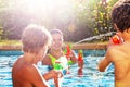 Group of friends play with water gun fight in pool Royalty Free Stock Photo