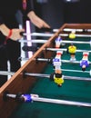 Group of friends playing kicker in a sports bar room, colleagues teammates play table football, table soccer game in the office, Royalty Free Stock Photo