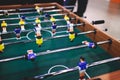 Group of friends playing kicker in a sports bar room, colleagues teammates play table football, table soccer game in the office, Royalty Free Stock Photo