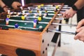 Group of friends playing kicker in a sports bar room, colleagues teammates play table football, table soccer game in the office, Royalty Free Stock Photo