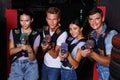 Group of friends playing laser tag game with laser guns in dark labyrinth