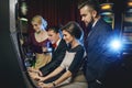 Group of friends playing slot machines in casino Royalty Free Stock Photo