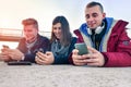 Group of friends playing with their smartphones