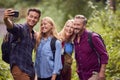 Group Of Friends Posing For Selfie In Countryside Taking Picture On Phone As They Hike Along Path Royalty Free Stock Photo