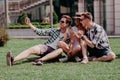 A Group Of Friends Posing For A Selfie Sitting On The Sunny Lawn.