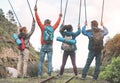 Group of friends raising hands up holding trekking poles on a peak of mountain - Young people exploring the nature