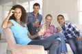 Group Of Friends Relaxing On Sofa Drinking Wine At Home Together Royalty Free Stock Photo