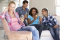 Group Of Friends Relaxing On Sofa Drinking Wine At Home Together Royalty Free Stock Photo