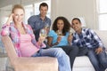 Group Of Friends Relaxing On Sofa Drinking Wine At Home Together Royalty Free Stock Photo