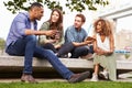 Group Of Friends Relaxing By Tower Bridge In London