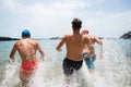 Group of friends running at the beach in to the water having fun and enjoying tehir vacations and holiday at summer - summer time Royalty Free Stock Photo