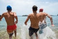 Group of friends running at the beach in to the water having fun and enjoying tehir vacations and holiday at summer - summer time Royalty Free Stock Photo