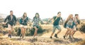 Group of friends running on grass meadow on country side - Happy friendship and freedom concept with young millenial people moving Royalty Free Stock Photo