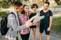 Group of friends searching location on city map.