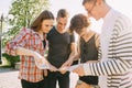 Group of friends searching location on city map. Royalty Free Stock Photo