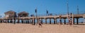 Group of friends are seen playing volleyball next to the Huntington Beach Pier Royalty Free Stock Photo
