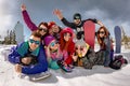 Group friends sit in snow with ski and snowboards winter weekend Royalty Free Stock Photo