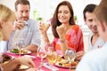 Group Of Friends Sitting Around Table Having Dinner Party