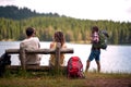 Group of friends is sitting beside the lake during a break of hiking the mountains. Trip, nature, hiking Royalty Free Stock Photo