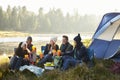 Group of friends sitting outside their tent near a lake Royalty Free Stock Photo