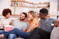 Group Of Friends Sitting On Sofa And Watching Movie At Home Whilst Eating Popcorn Royalty Free Stock Photo