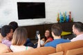 Group Of Friends Sitting On Sofa Watching TV Together Royalty Free Stock Photo