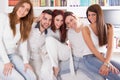 Group of friends smiling and sitting together on sofa at home Royalty Free Stock Photo