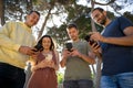Group of friends smiling while using the mobile phone Royalty Free Stock Photo
