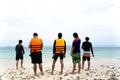 Group of friends standing on the beach and recording video with Royalty Free Stock Photo