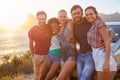 Group Of Friends Standing By Car On Coastal Road At Sunset Royalty Free Stock Photo