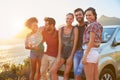 Group Of Friends Standing By Car On Coastal Road At Sunset Royalty Free Stock Photo