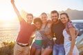 Group Of Friends Standing By Car On Coastal Road At Sunset Royalty Free Stock Photo