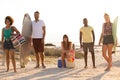 Group of friends standing and looking at camera at beach on a sunny day