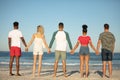 Group of friends standing together hand in hand on the beach Royalty Free Stock Photo