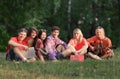 Group of friends students with books and guitar sitting on the grass in the Park Royalty Free Stock Photo