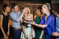 Group of friends surprising a woman with birthday cake