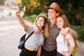 Group of friends taking selfie at camera in city