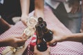 Group of Friends toasting drinks. Close-ups hands of friends toasting wine glass and beers in the dinner party.