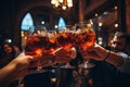 Group of friends toasting with glasses of wine at bar or pub. Close up of group of people clinking glasses with cocktails in pub,