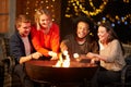 Group Of Friends Toasting Marshmallows By Firepit Royalty Free Stock Photo