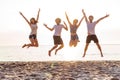 Group of friends together on the beach having fun. Happy young people jumping on the beach. Group of friends enjoying Royalty Free Stock Photo