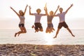 Group of friends together on the beach having fun. Happy young people jumping on the beach. Group of friends enjoying Royalty Free Stock Photo